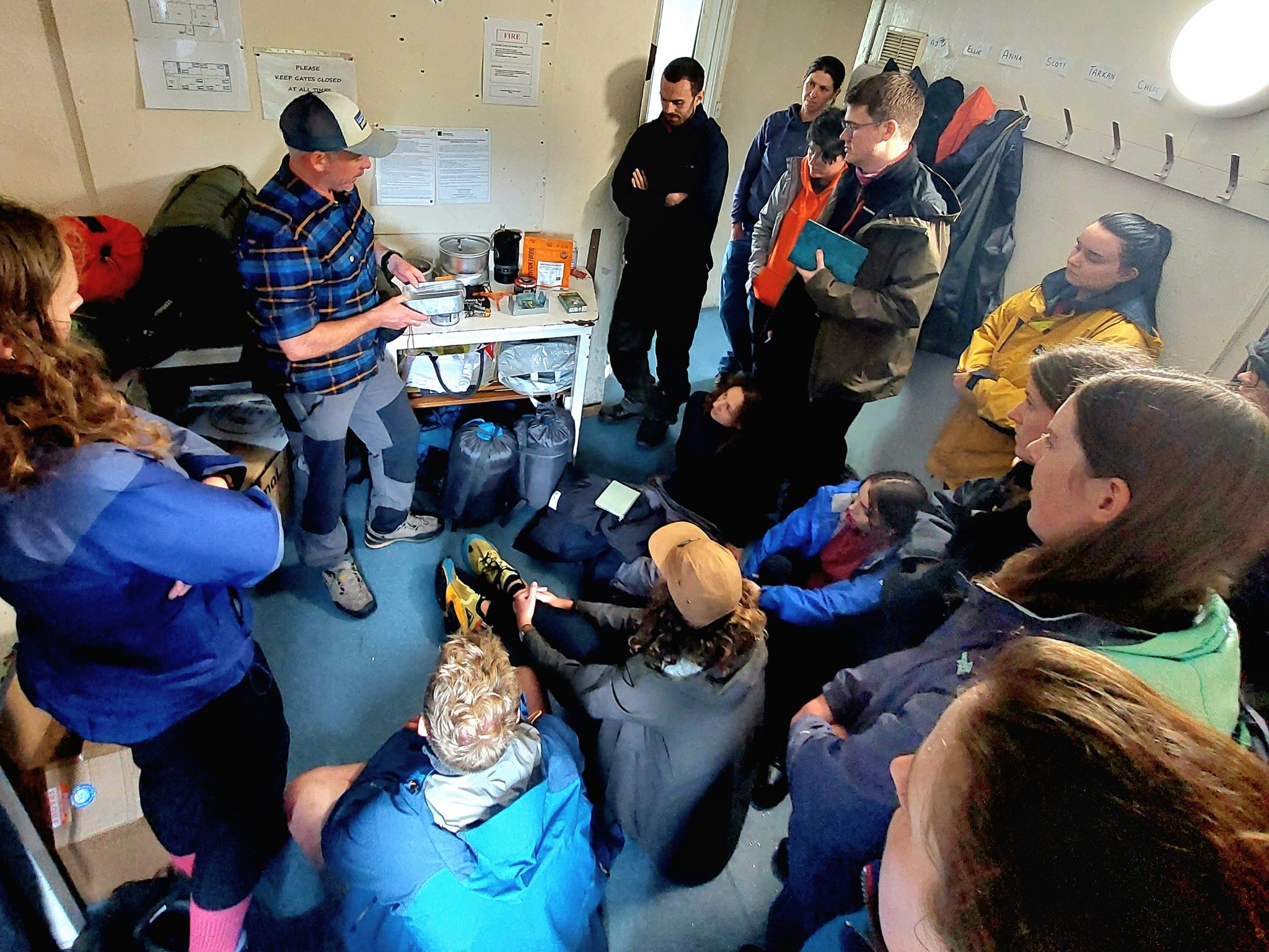 Antony demonstrating expedition cooking equipment to course participants indoors